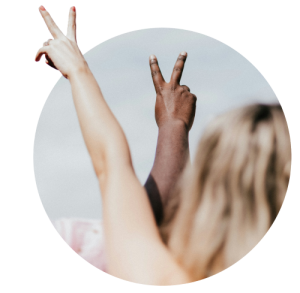 Close-up of two hands of different skin tones making peace signs against light background